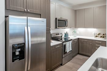 A modern kitchen with a stainless steel refrigerator and oven.